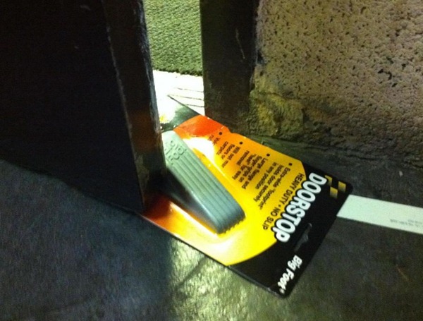 Doorstop, still in its packaging, being used to prop a door ajar