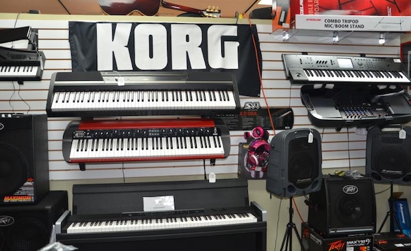 Keyboards on a wall display at a pawn shop under a “KORG” banner.
